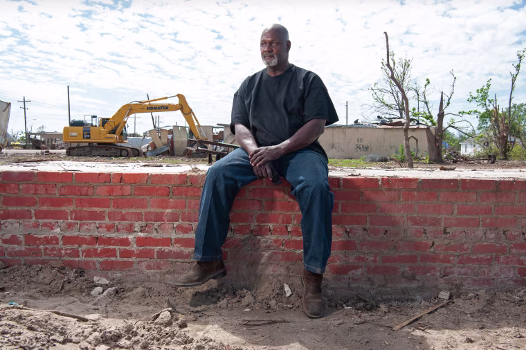 Sammy Jackson sits on all that remains of his house in Rolling Fork, Miss.