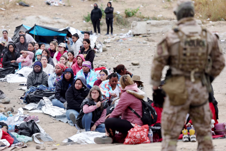 Asylum-seekers wait in a makeshift camp between border walls on May 13, 2023 in San Diego.