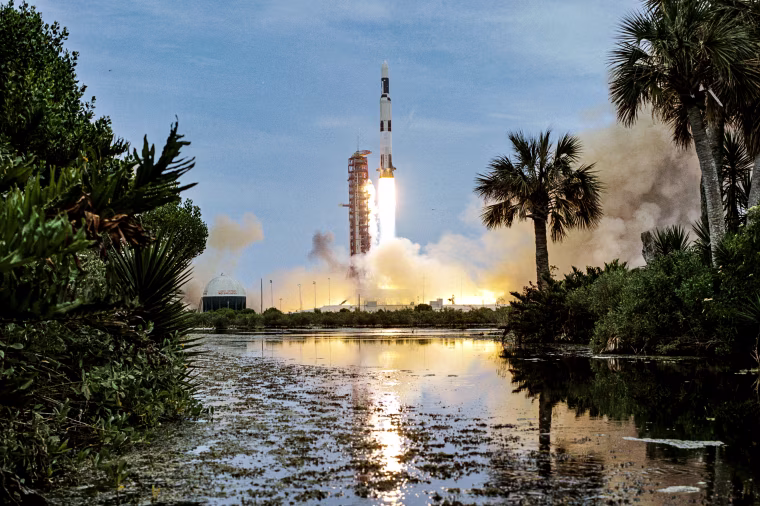 Clouds of smoke billow out over the surrounding area as the uncrewed Skylab 1/Saturn V space vehicle launches from NASA’s Kennedy Space Center on May 14, 1973.