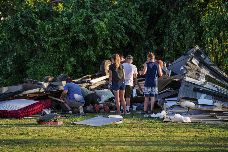 People survey what's left of an RV camper after a tornado touched down in several areas of Greenwood, Ind., on Sunday afternoon, June 25, 2023. 