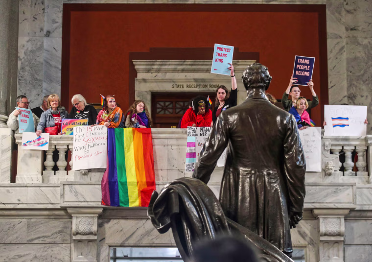 Behind a statue of Abraham Lincoln, demonstrators rally in the Kentucky capitol rotunda to oppose SB 150, a bill that would ban gender-affirming care for trans youth, on March 29, 2023.