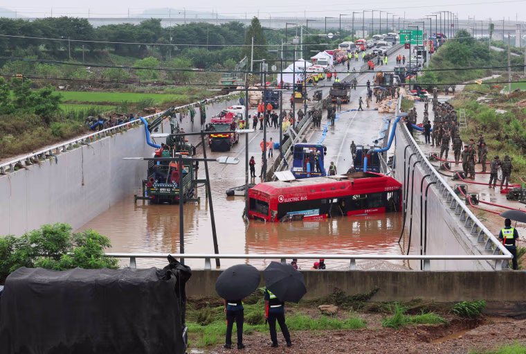 Rescuers battled to reach people trapped in a flooded tunnel Sunday in South Korea, where at least 33 people have died and 10 are missing after heavy rains caused flooding and landslides.