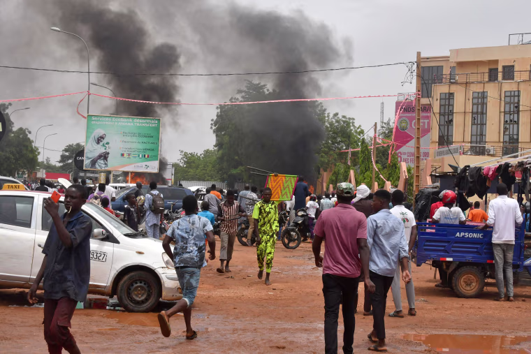 Smoke billows as supporters of Niger's security forces attack the headquarters of the Nigerien Party for Democracy and Socialism, the party of overthrown President Mohamed Bazoum, in Niamey on July 27, 2023.