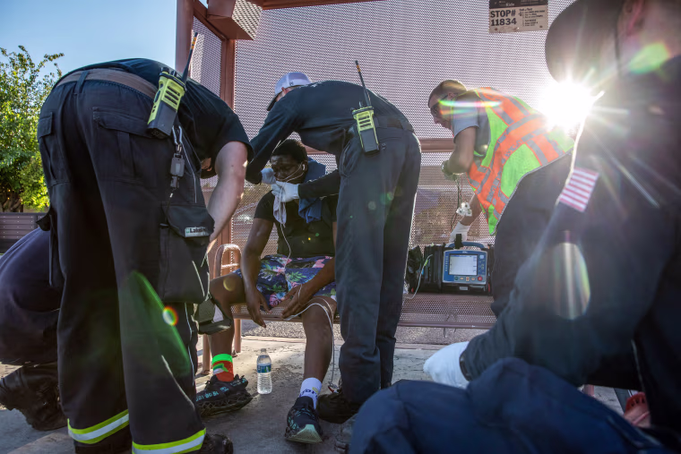 Firefighters from Phoenix Fire Engine 18 start a breathing treatment for a resident having trouble breathing during a heat wave in Phoenix on July 20, 2023.