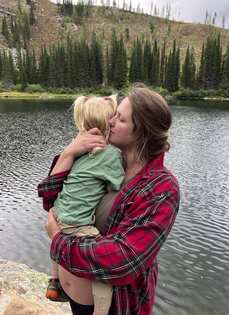 Image: Lauren Sanders, six months pregnant, holds her daughter, 2 and a half.