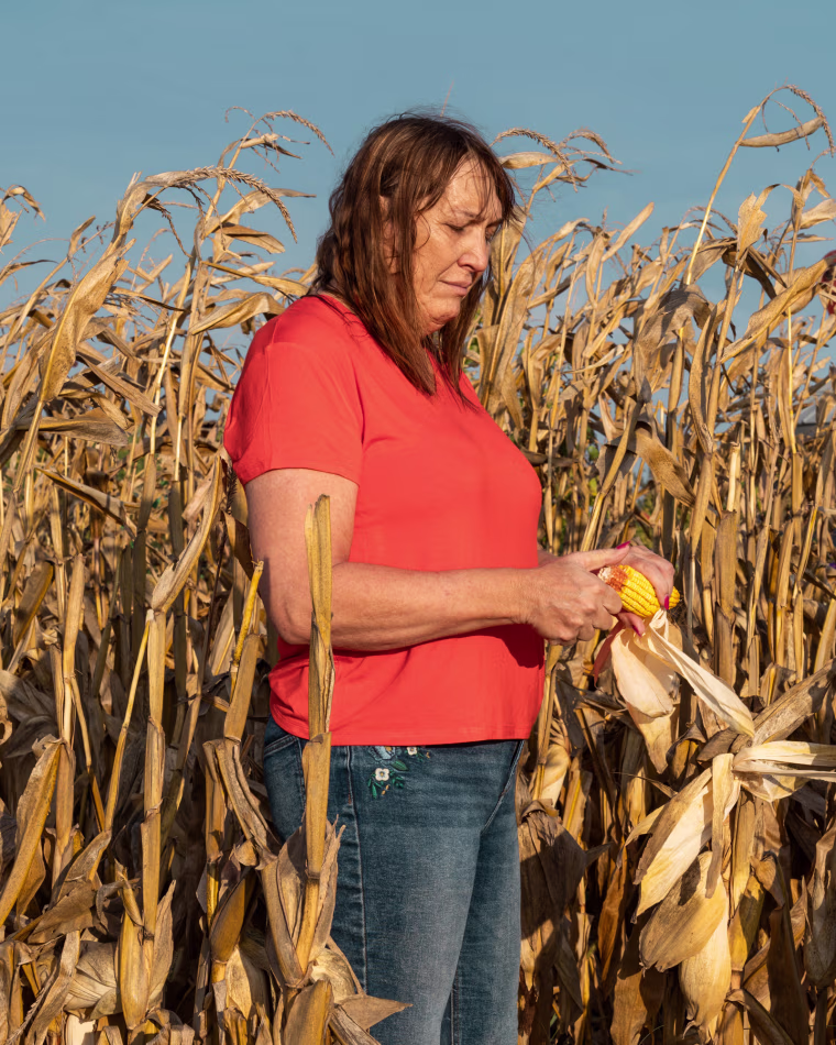 Ashley Swartz holds an ear of corn at her farm in Malmo, Nebraska.