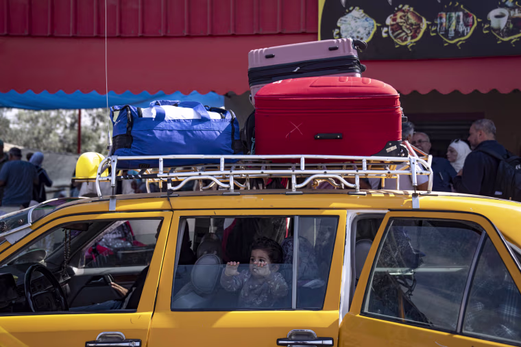 People wait to cross into Egypt at the Rafah border crossing in Gaza.