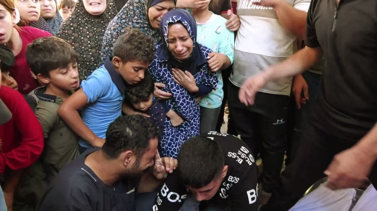 Muna Habil and others look at bodies recovered from the rubble.