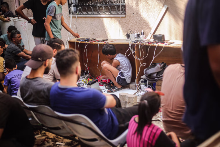 A Palestinian boy sits under the table inside the Al-Amal