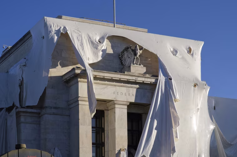 The sculpture of an eagle looks out from behind protective construction wrapping as the Federal Reserve Board Building undergoes renovations on Oct. 23, 2023.