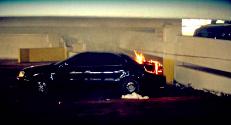 1992 Black Acura with flames scorching its trunk.