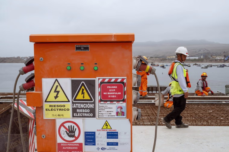 Signs on the construction site are displayed in both Spanish and Chinese.