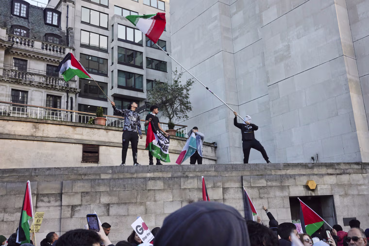 Protesters stand on a the roof of a building at a march demanding a ceasefire in Gaza on Nov. 11, 2023 in London.