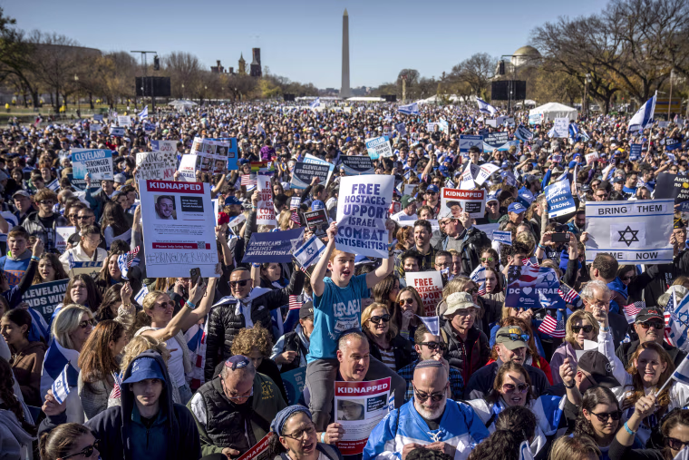 Image: Participants hold signs as they stand on the National Mall at the March for Israel