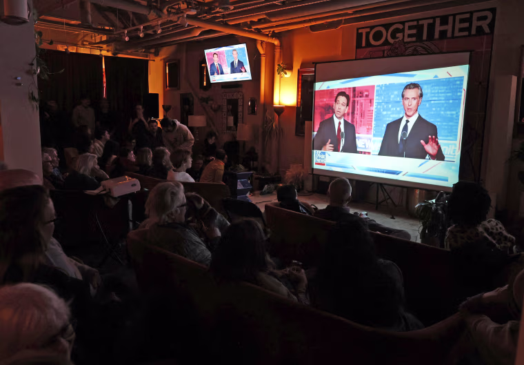 California Gov. Gavin Newsom and Florida Gov. Ron DeSantis debate on a screen during a watch party at Manny's on Nov. 30, 2023 in San Francisco.