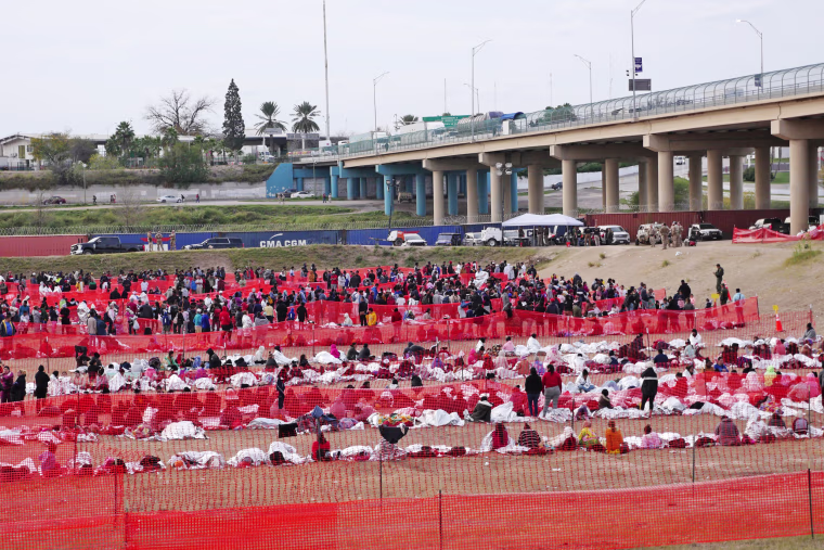 Immigrants wait to be processed at a U.S. Border Patrol transit center after they crossed the border from Mexico in Eagle Pass, Texas, on Dec. 20, 2023.