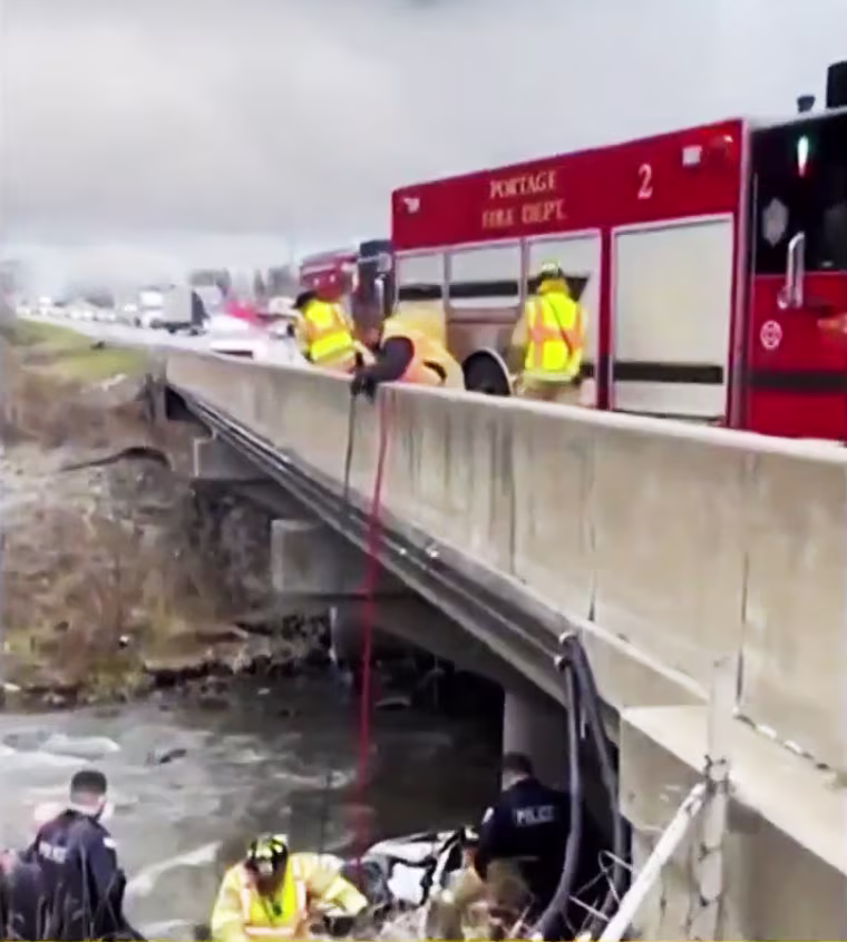 Members of Portage Fire Dept. help rescue a driver who was stuck in his mangled car in a creek off of I-94 for days.