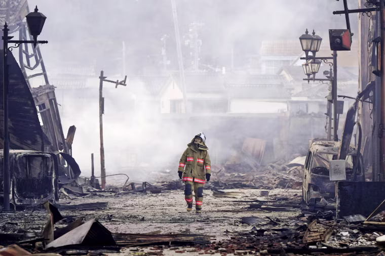 A firefighter walks through the rubble and wreckage of a burned-out marketplace in Wajima in Japan's Ishikawa prefecture on Jan. 2, 2024.