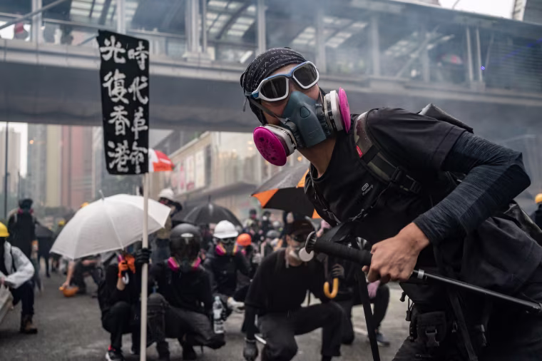 Protesters throw a brick at police during a clash at an anti-government rally in Tsuen Wan district in Hong Kong,