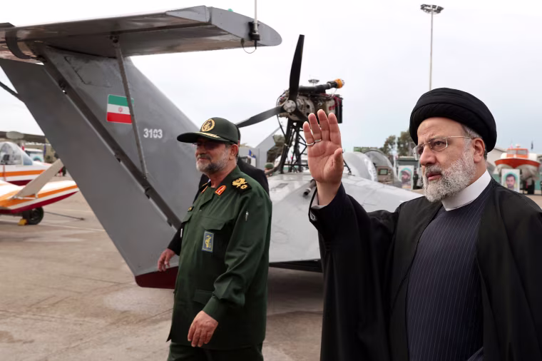 Iranian President Ebrahim Raisi waves as he visits an exhibition.