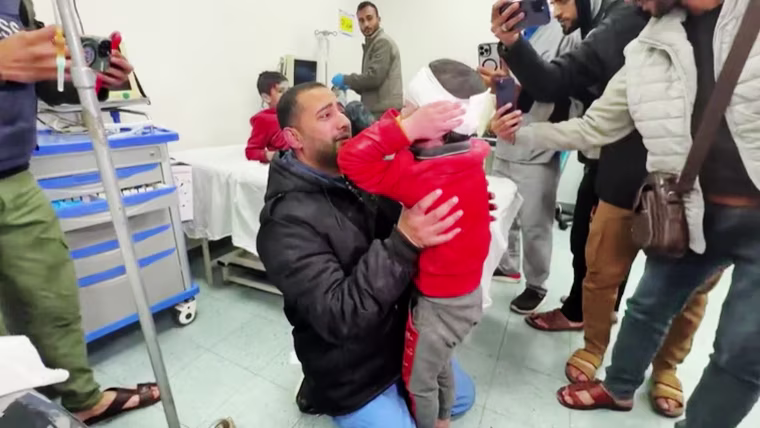 Palestinian doctor Dr. Rami Abu Libdeh holds his 9-year-old son, Mohammad, at a hospital in Rafah, Gaza, on Feb. 8, 2024.