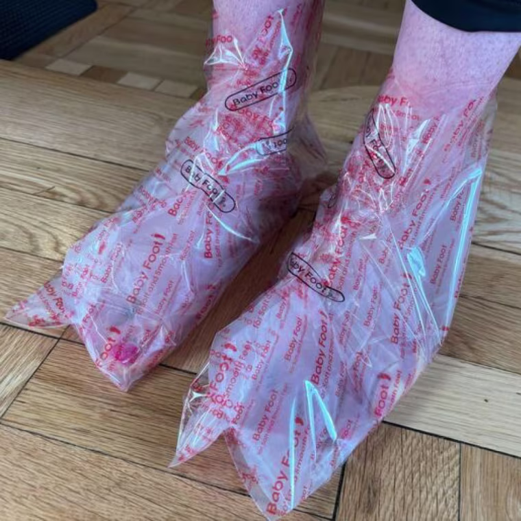 Staffer wearing the Baby Foot booties, which are and secured with the Baby Foot stickers that come in the set.