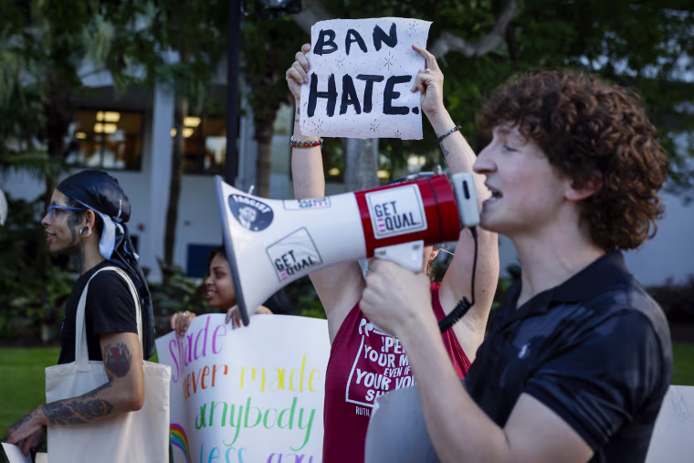 A demonstrator holds a placard reading "Ban Hate" during a 'Walkout 2 Learn' rally