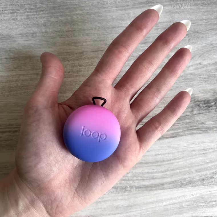 Picture of a hand holding a Loop Quiet earplugs case on the palm.