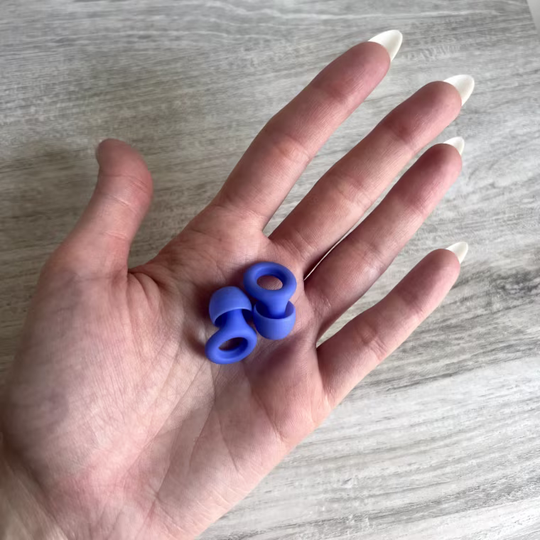 Person holding a pair of Loop Quiet earplugs in the palm of their hand.