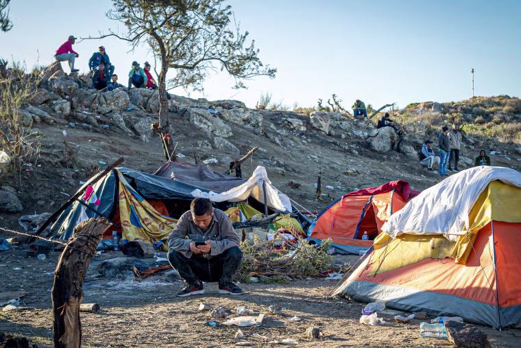A Chinese migrant sits in front of his tent near the U.S. - Mexico border.