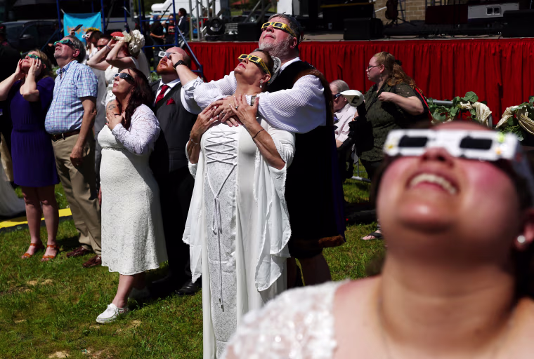 Image: Couples look at the eclipse during a mass wedding ceremony in Russellville, Ark.