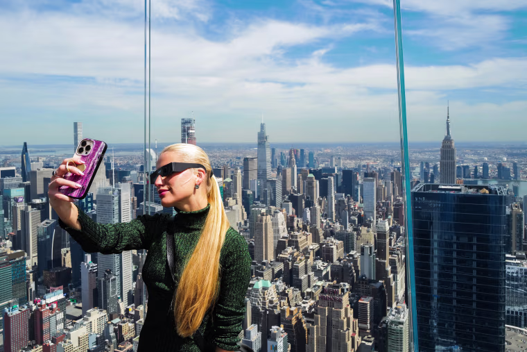 A woman takes a photo at the Edge at Hudson Yards observation deck in New York ahead of the total solar eclipse across North America.