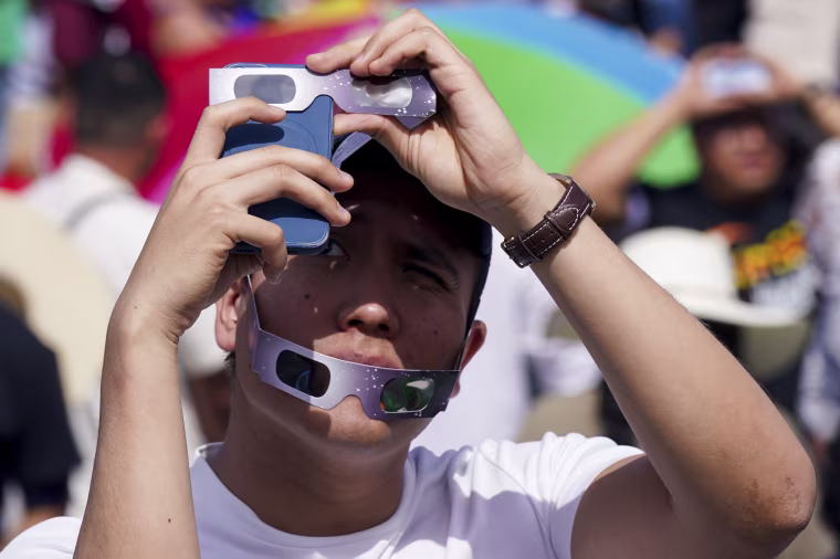 A man takes a photo of the total solar eclipse in Mazatlán, Mexico.