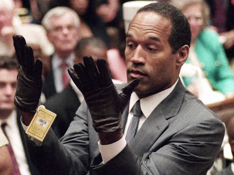 O.J. Simpson holds up his hands before the jury after putting on a new pair of gloves similar to the infamous bloody gloves during his double-murder trial in Los Angeles on June 21, 1995.