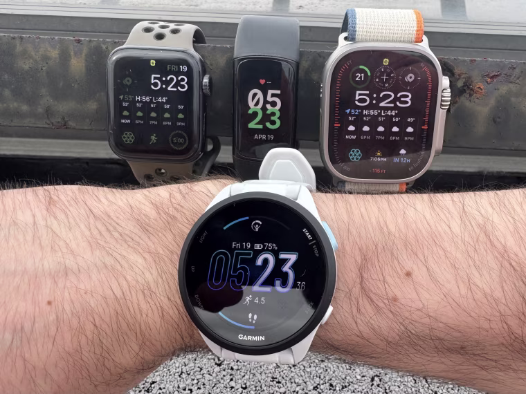 Close up shot of the Forerunner 165 (front) alongside the Apple Watch SE, Fitbit Charge 6 and Apple Watch Ultra 2 (back).