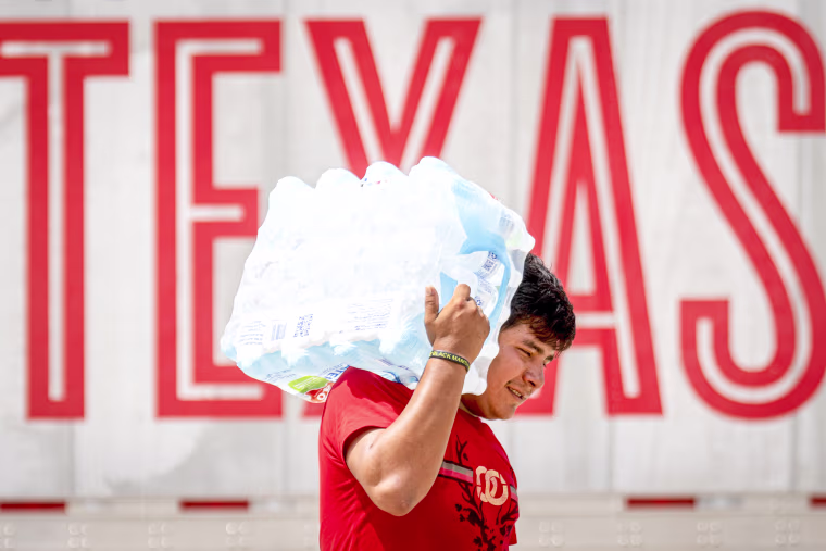 A man carries water on his shoulder.