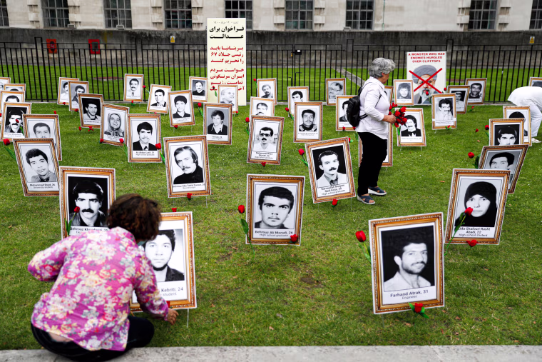 A protester places flowers on a photograph of an executed man 