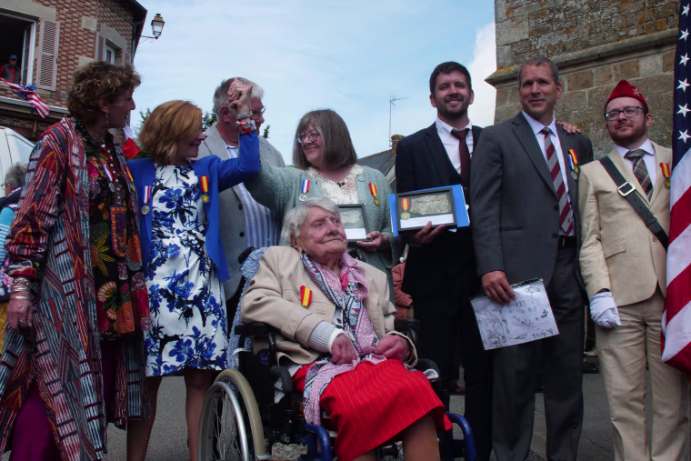 Nicole and Mireille hold hands aboved Marie Bastien at a ceremony for Paul Chaufty.