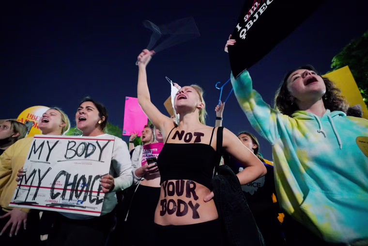 A crowd outside the Supreme Court with signs that read, "My Body My Choice" and "Not Your Body"