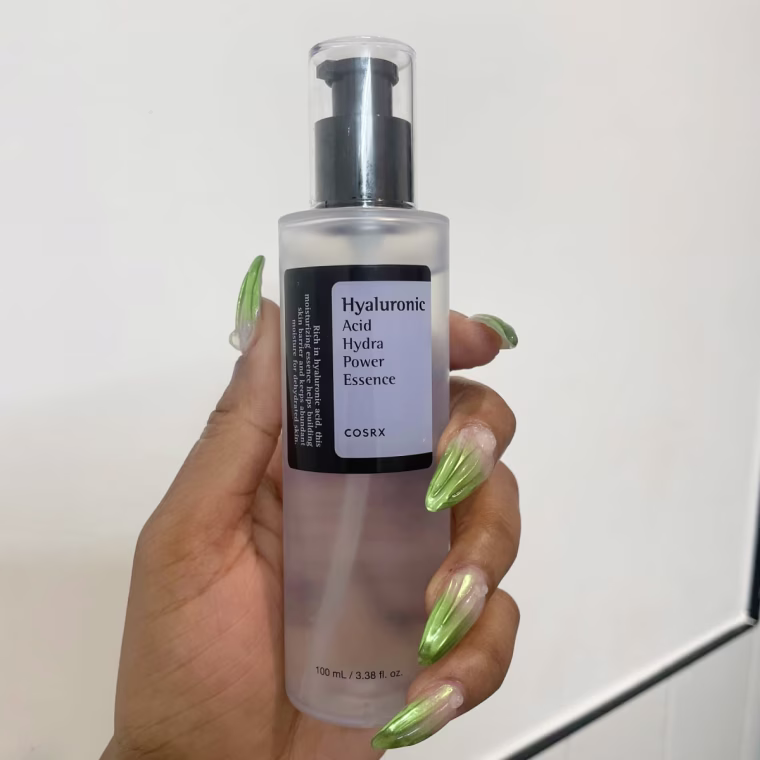 Hand holding bottle of CosRx Hyaluronic Acid Hydra Power Essence