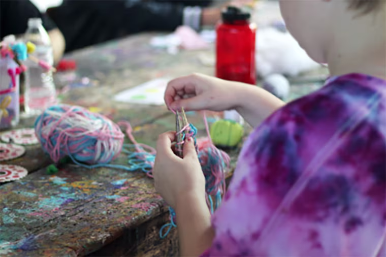 A camper knitting at Camp Lilac in Ohio.