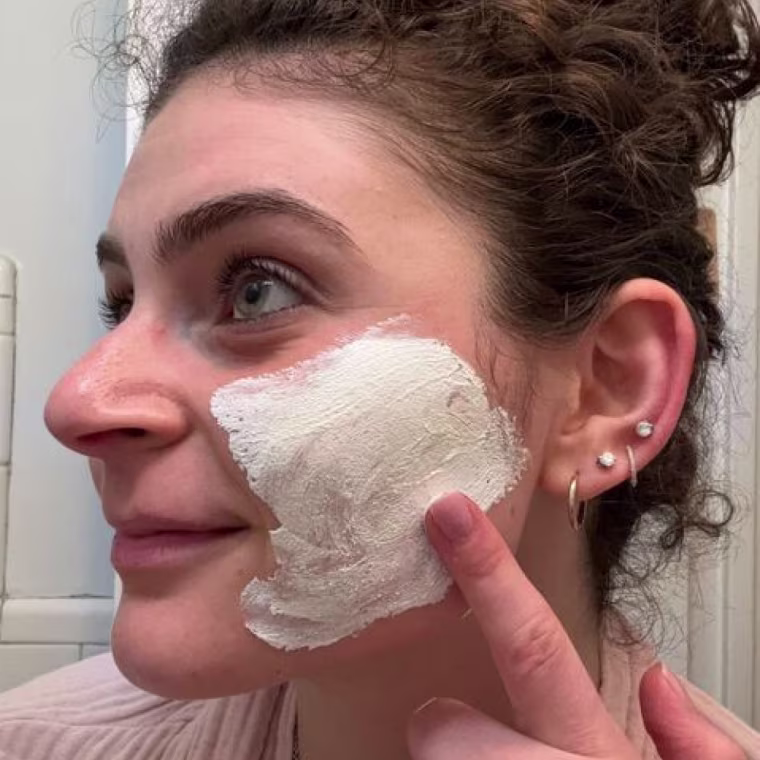 NBC Select associate updates editor Zoe Malin applies the Philosophy Purity Made Simple Pore Extractor Exfoliating Clay Mask to her left cheek.