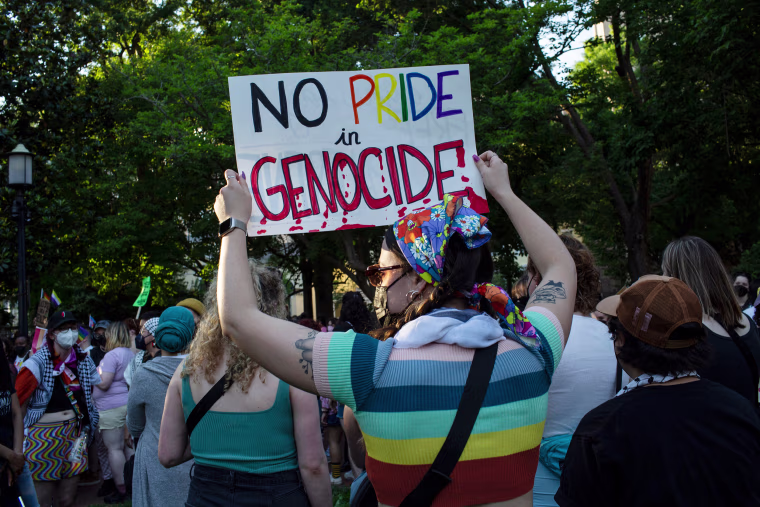 An activist holding a sign with No Pride in Genocide