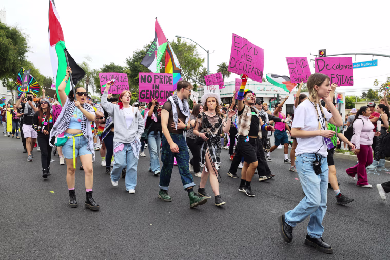 Pro-Palestinian activists march holding signs