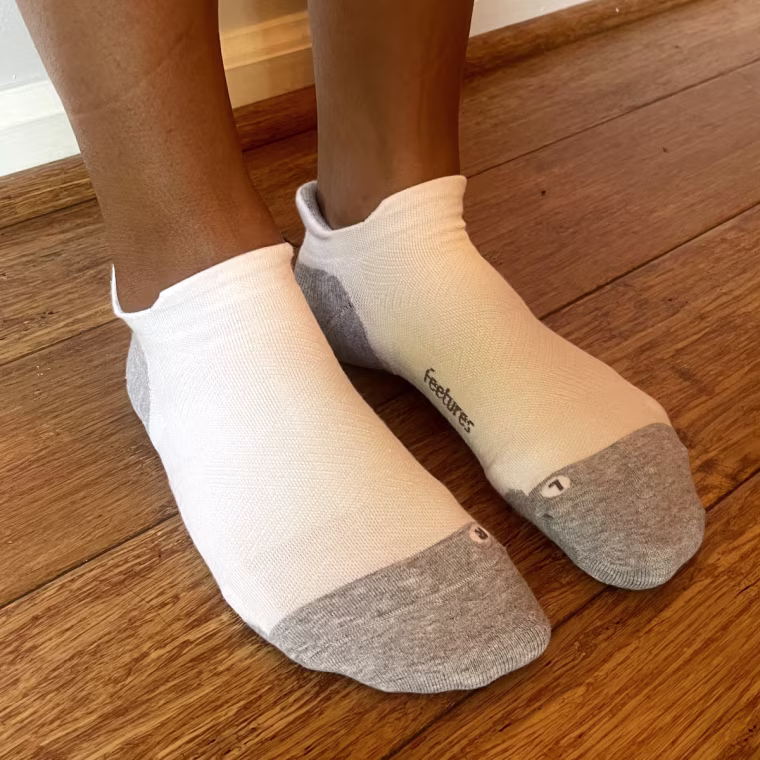 Alvarez wearing a pair of white Feetures no-show socks on both feet without any shoes