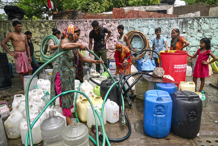 Residents fold pipes after filling their containers with water