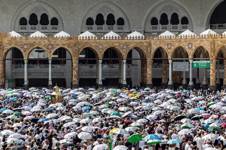 Pilgrims carry umbrellas