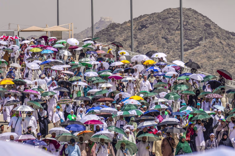 Image: Muslim pilgrims use umbrellas to shield themselves from the sun