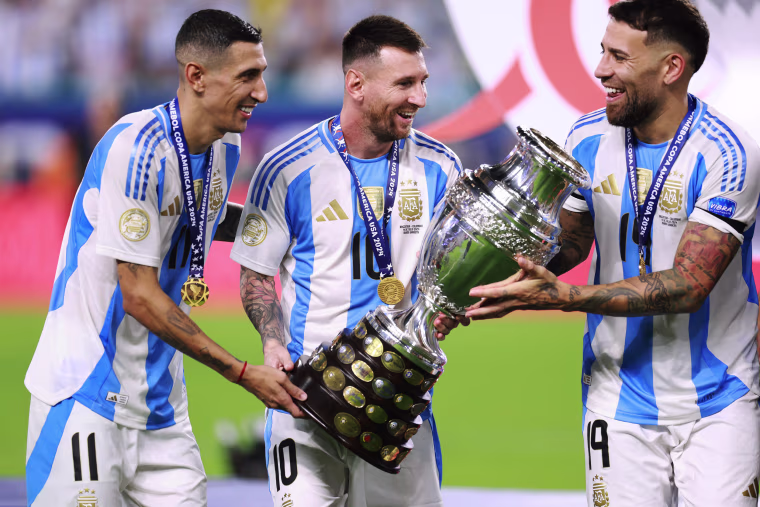 Angel Di Maria, Lionel Messi and Nicolas Otamendi of Argentina celebrate with the trophy
