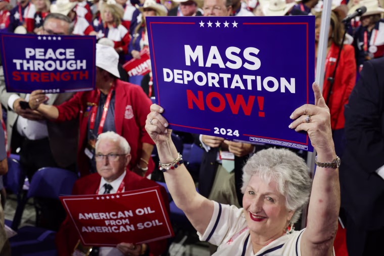 People hold "Mass Deportation Now!" signs at the Republican National Convention in Milwaukee